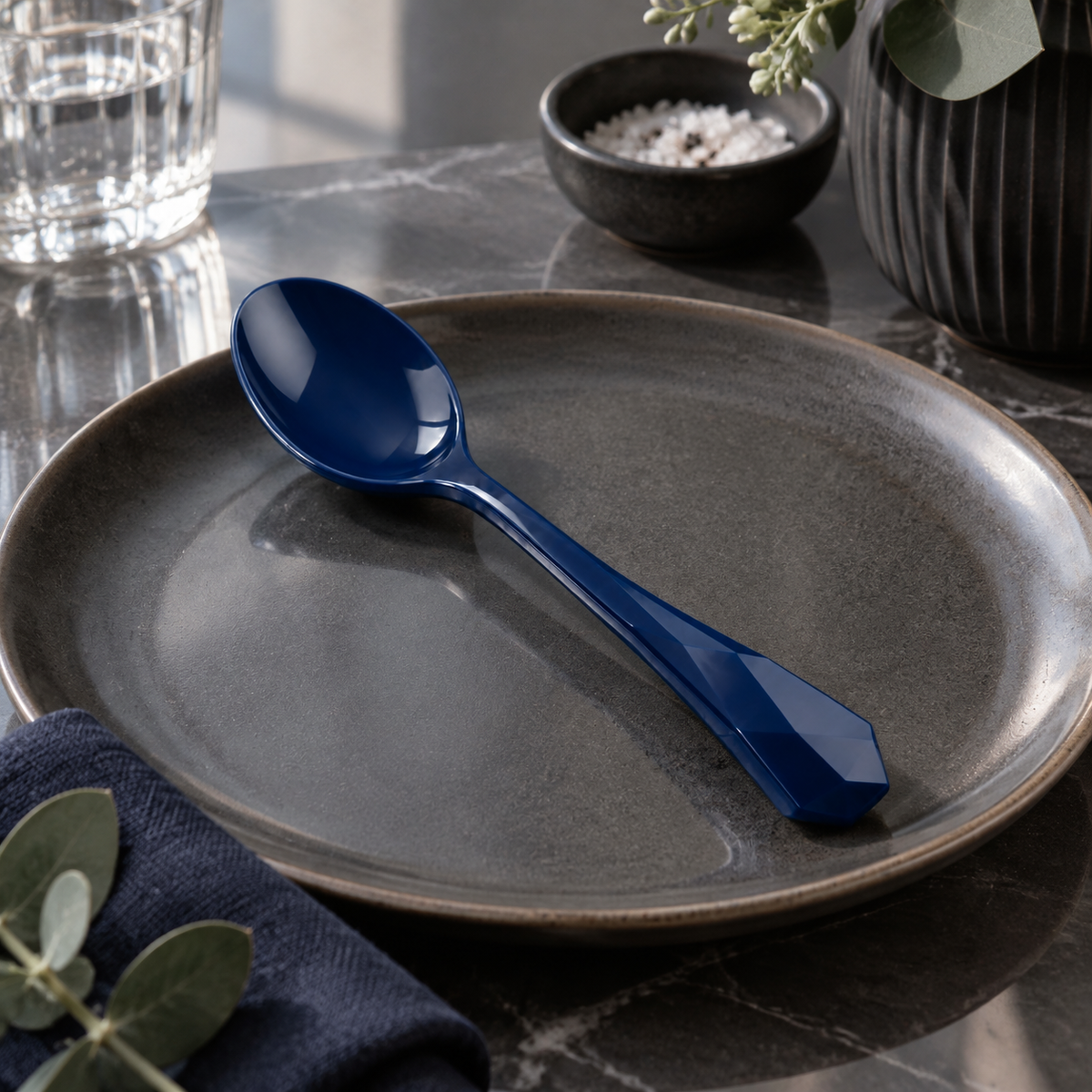 Side view of a deep blue plastic spoon with unique handle.