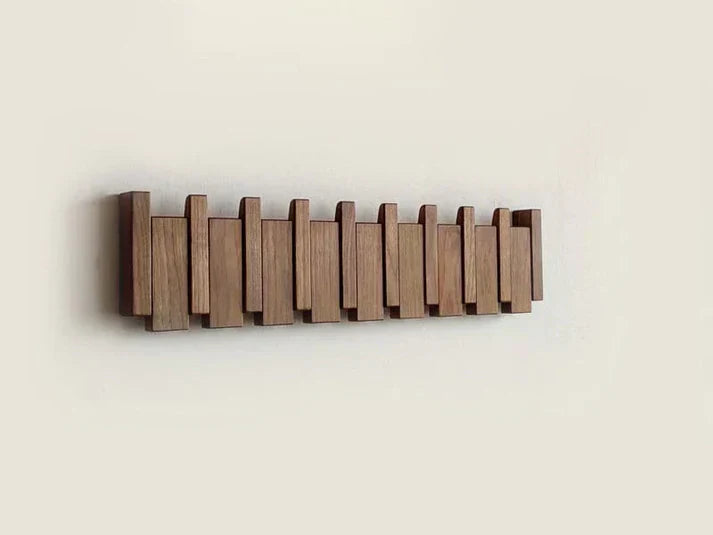 Wooden wall mounted coat rack with flip-down piano key hooks